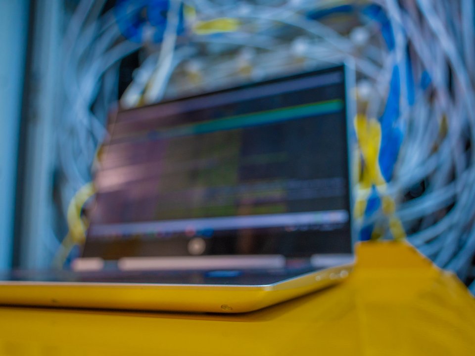 Ein geöffnetes Laptop auf einem gelben Tisch.