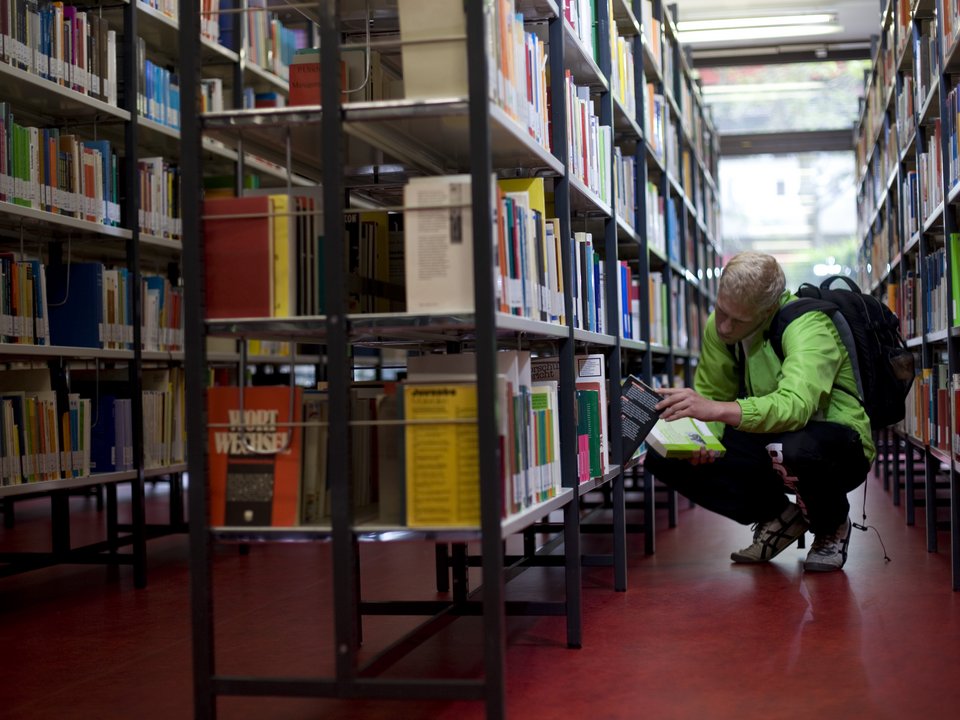 Ein Student sucht ein Buch in der Bibliothek