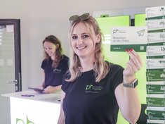 Eine Mitarbeiterin des SSZ hält eine Postkarte zum Thema Bewerben in die Höhe