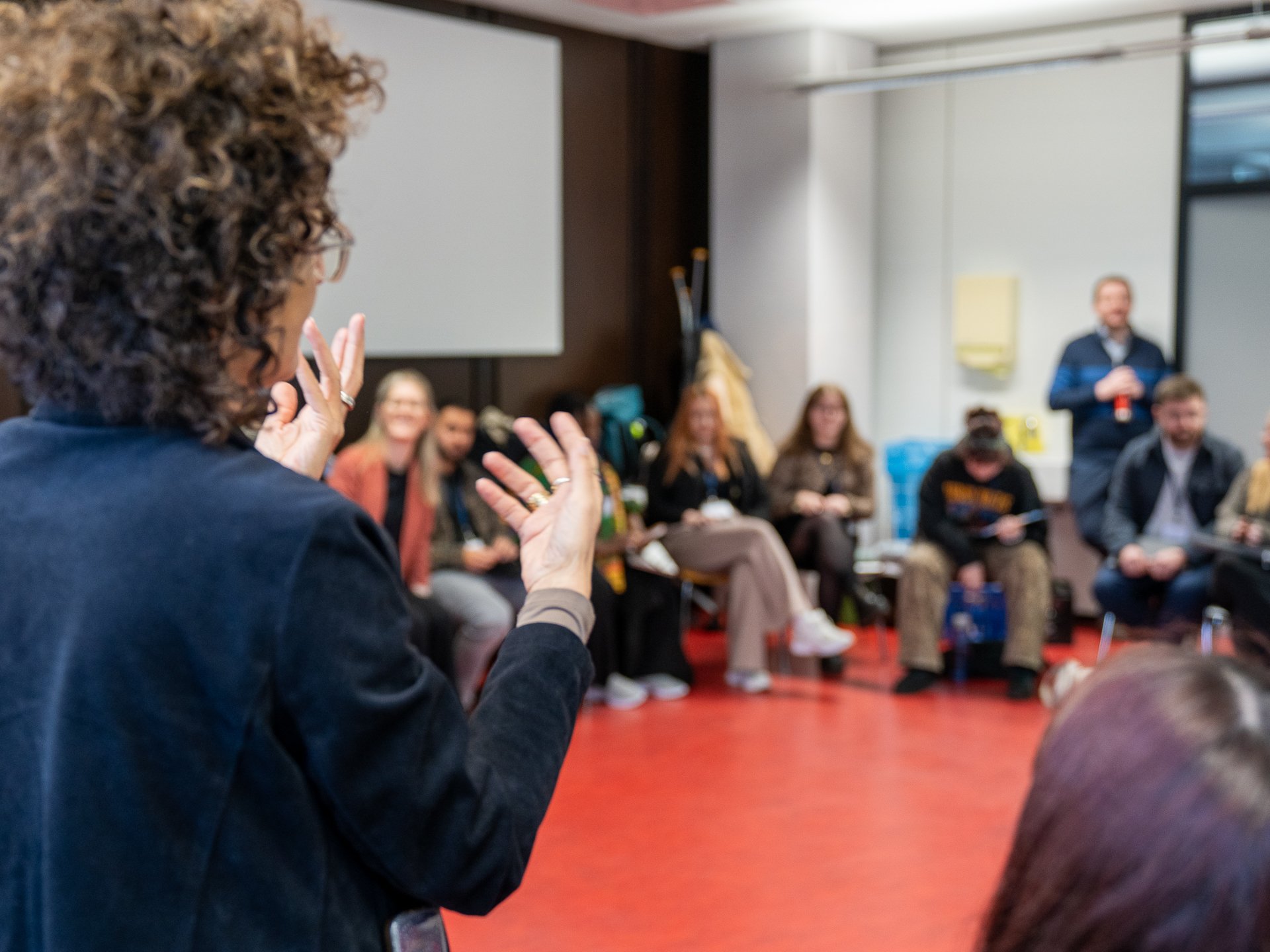 Eine Person spricht vor einer Gruppe.