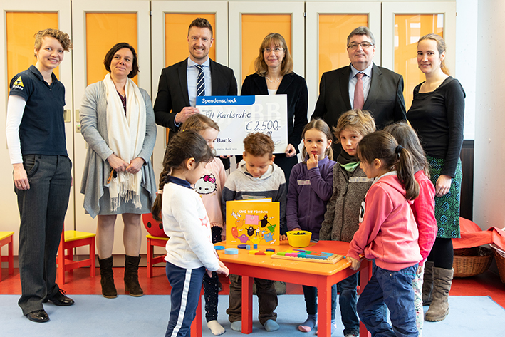 Spendenübergabe in der MiniMa-Werkstatt: BBBank-Regionaldirektor Benjamin Burger (3.v.l.), Prof. Dr. Christiane Benz (4.v.l.), Johanna Zöllner (2.v.l.) und Prof. Dr. Klaus Peter Rippe (2.v.r.). Außerdem Mädchen und Jungen der Kita „Haus  für Kinder“ in Landau. Foto: Tilman Binz / Pädagogische Hochschule Karlsruhe