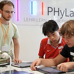 Ein Studierender im Lehr-Lern-Labor Physik leitet jugendliche Schüler an
