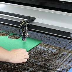 Eine Person bedient einen Lasercutter