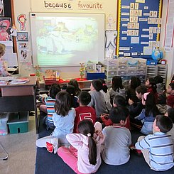 Eine Grundschulklasse schaut auf das Smartboard.