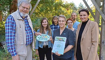 „Natur im Garten“: Harald Schäfer (l.) überreichte Prof. Dorothee Benkowitz (M.) Urkunde und Plakette. PHKA-Prorektorin Prof. Annette Worth (r.) gratulierte zur Auszeichnung. Foto: PHKA